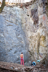 rock climber climbs an almost vertical wall of rock with a safety rope