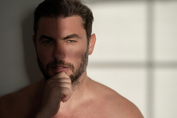 Fototapeta premium Close up portrait of attractive man for cream on male face cosmetics advertising. Naked shoulders, skin care, health, cosmetics for skin. Male beauty. Shaving, hair styling.