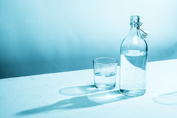 Clear glass water bottle with glass, cyan tinted

