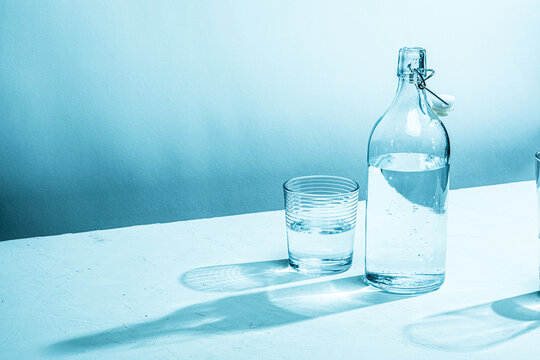 Clear glass water bottle with glass, cyan tinted

