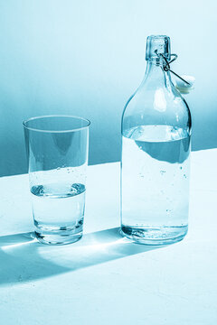 Clear glass water bottle with glass, cyan tinted

