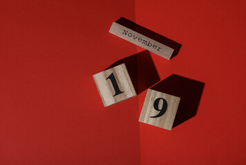 Wooden calendar with the date November 19 on a red background