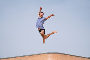 Obraz premium Young man is making a jump in the air, expressing freedom and happiness