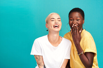 Girls, laughing and portrait with joke, together and bonding on blue background as friends. Female...