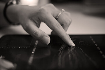 Close-up view of person's hand interacting with digital screen, analyzing data Chart and graphs visible on display creating interaction with digital interface