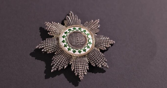 Detailaufnahme Rotation eines alten Ordens vor schwarzem Hintergrund