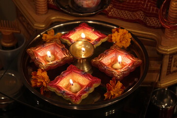 Clay diyas with flames and marigolds for Diwali (Indian festival of lights)