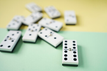 White domino blocks on yellow and green background. High angle shot.