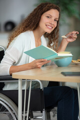 handicapped woman holding cup reading book