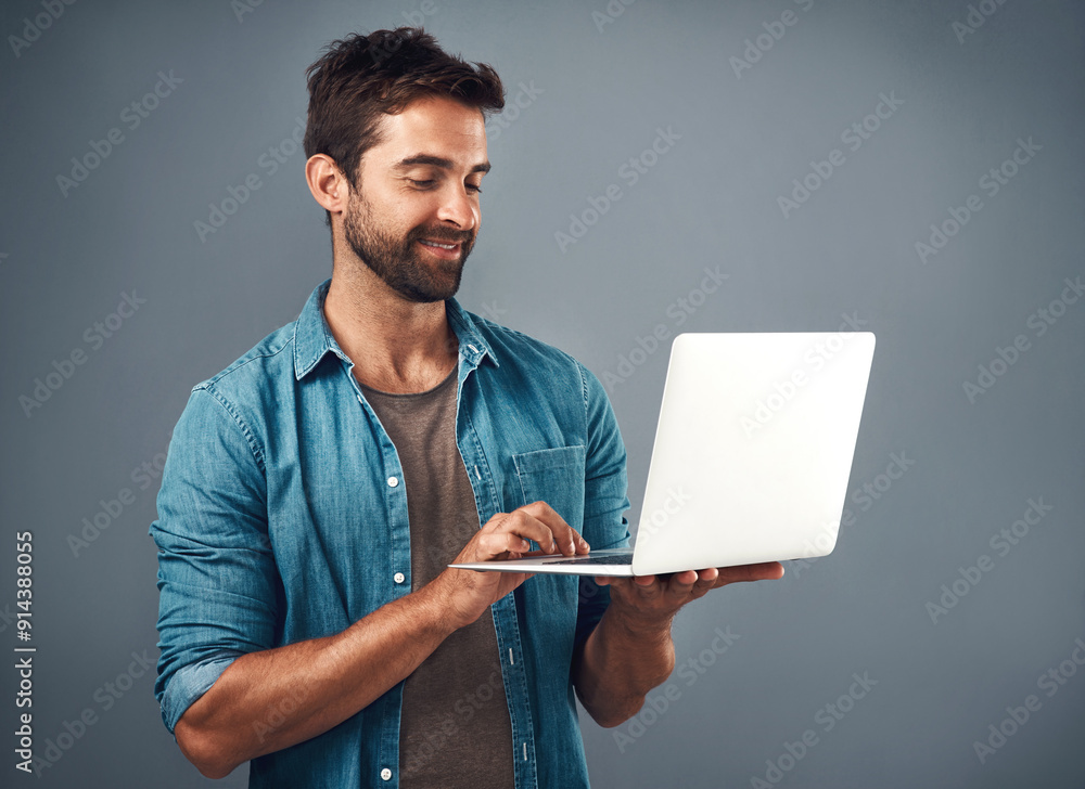 Poster Laptop, smile and man in studio with research for creative software with project development. Happy, technology and male graphic designer working on multimedia art on computer by gray background.