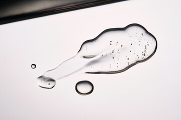 A smear of cosmetic gel close-up on a gray background. Appetizing texture with bubbles.