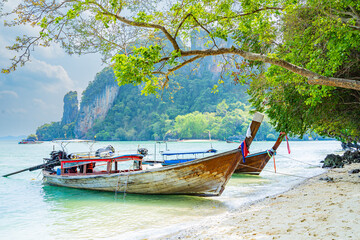 Obraz premium Beach and long-tail boats moored along the sandy beach in the southern sea of ​​Krabi province, Thailand, Asia