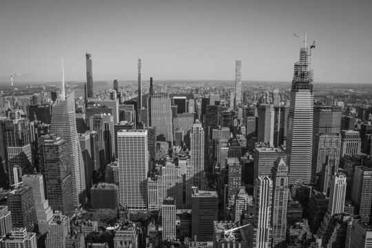Fototapeta Aerial panoramic black and white view of Manhattan, showcasing countless skyscrapers and the distant horizon. A powerful and urban, yet sober image