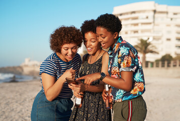 Friends, women and phone on beach for reading social media comment, view photo album and...