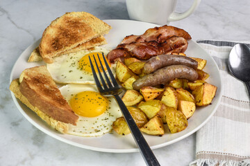 fried eggs served   bacon and sausages  and home fries