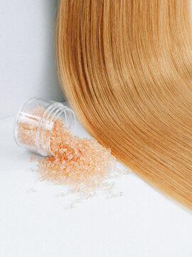keratin capsules for hair extensions on light hair background