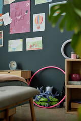 Vibrant children's room featuring various colorful drawings on dark wall and scattered toys creating a playful ambiance Camera is slightly tilted, focusing on one side of the playful space