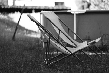 two deck chairs standing on the grass, black and white photo