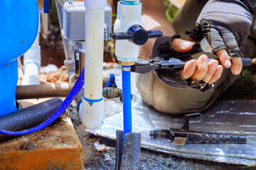 PVC pipe is being connected to water supply artesian well system pump house