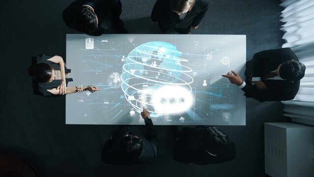 Top down aerial of business team brainstorm idea about digital communication or global network connection. Group of diverse business people discuss about data processing at meeting room. Directorate.