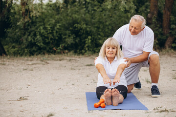 Senior Couple Practicing Outdoor Yoga Exercise Together in Nature