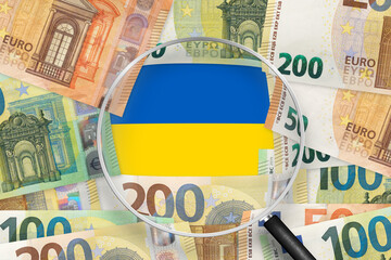 Euro notes with Ukraine flag view through magnifying glass. EUR is the official currency of the...