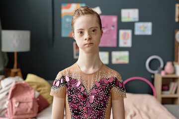 Portrait of young girl with Down Syndrome wearing an artistic costume adorned with colorful...