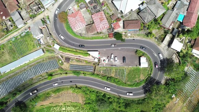 Northern mountainous part of Bali island in Indonesia, curved road in the center of Bali island, top down view