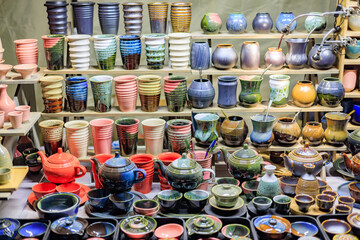 A counter with beautiful ceramic teapots and cups.