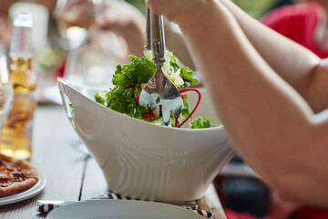 Hands, diet and salad at restaurant celebration for brunch, birthday and serving as outdoor event. Group of people, food and eating lunch at diner for nutrition, party and social reunion in Italy