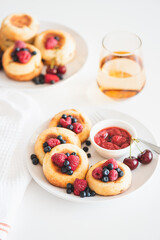 Homemade cottage cheese pancakes with fresh berries on white table