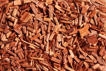Background made of red sandalwood chips, top view
