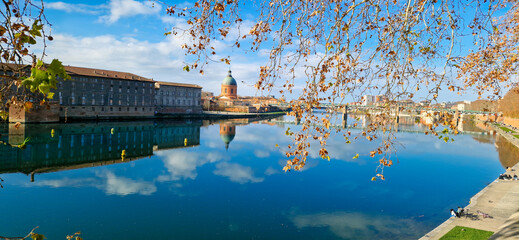 Panoramic View of Saint Pierre Bridge and La Grave Hospital Reflecting in the Garonne River at Sunrise, Bathed in Golden Sunrise Light with a Clear Blue Sky, Toulouse