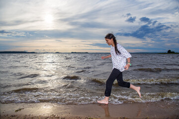 Photo of a person in motion. A girl runs along the seashore