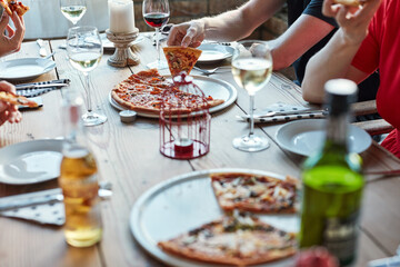 Friends, pizza and drinks at restaurant on table for brunch, birthday and celebration as outdoor event. Group of people, food and beer or wine at city pub for lunch, party and social reunion in Italy