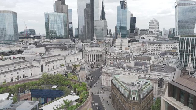 Drone aerial shot flying in towards the Bank of England in Central London, with the high rise skyscrapers in the background on a normal cloudy day
