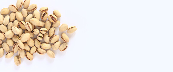 Pistachios on a white background. A handful of dry salted pistachios on a light background, selective focus. Pistachio with shell. Close-up