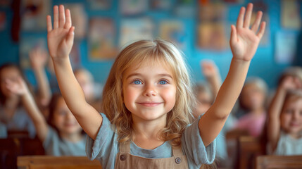 Cheerful young blonde girl with blue eyes, raising her hand in a lively classroom setting, surrounded by other enthusiastic students.