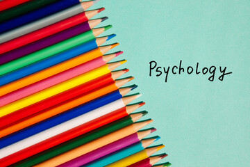 Fototapeta premium Psychology - card in text and colorful different pencils on green background 