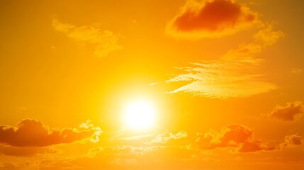 Fototapeta premium Bright orange sun in a vibrant sunset sky with clouds