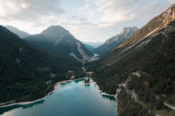 Obraz premium Tranquil mountain lake surrounded by lush forests and high peaks.