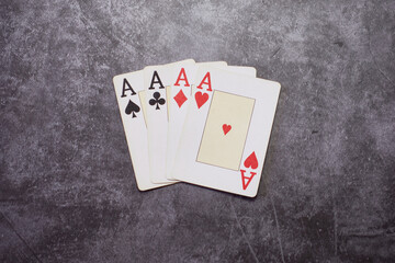 Four French suited deck playing cards with poker of aces on a textured table
