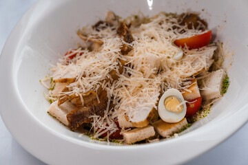 Caesar salad with chicken on a white plate