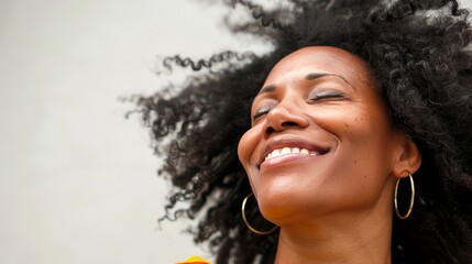 Joyful woman with hair blowing in the wind on white background in a happy moment