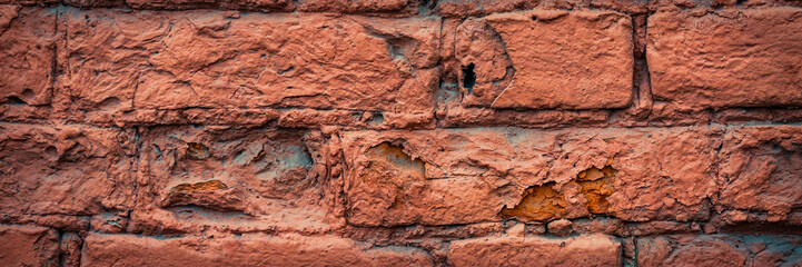 Old red brick wall. The texture of weathered grungy brickwork. Wide panoramic background with masonry.