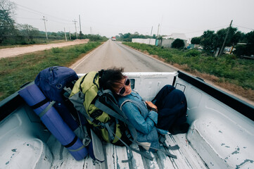 Asian girl hitchhiking in a pickup truck in latin america