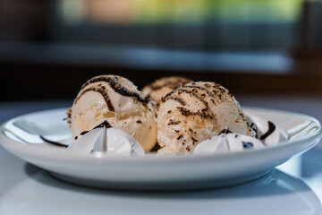 Ice cream with fruits and chocolate on a white plate