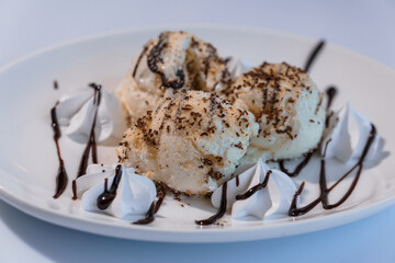 Ice cream with fruits and chocolate on a white plate