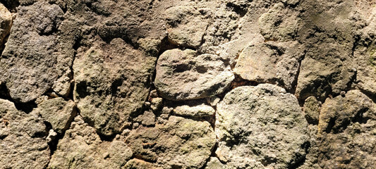 old stone wall with shadows and sunlight, rustic background