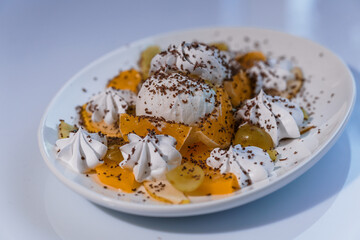 Ice cream with fruits and chocolate on a white plate